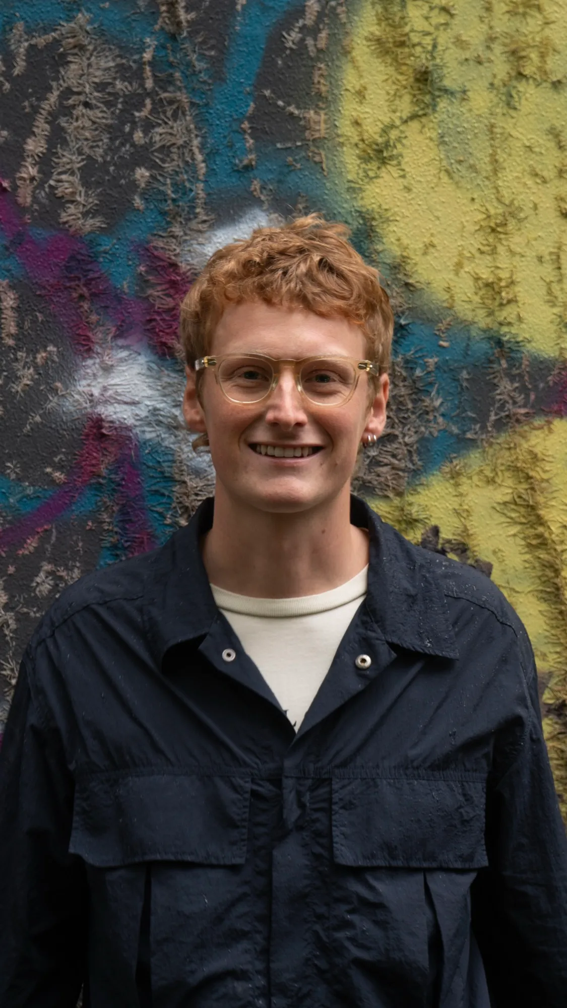 Portræt af Matias Brogaard foran en væg med graffiti